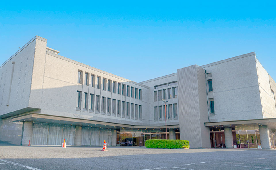 青空の下に広がる落合斎場の建物全景と広大な駐車場エリア
