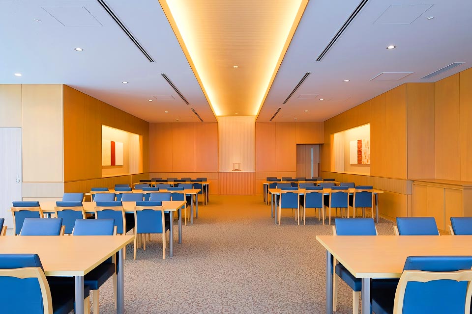 温かみのある照明とブルーの椅子が整然と並ぶ、四ツ木斎場の広々とした控室